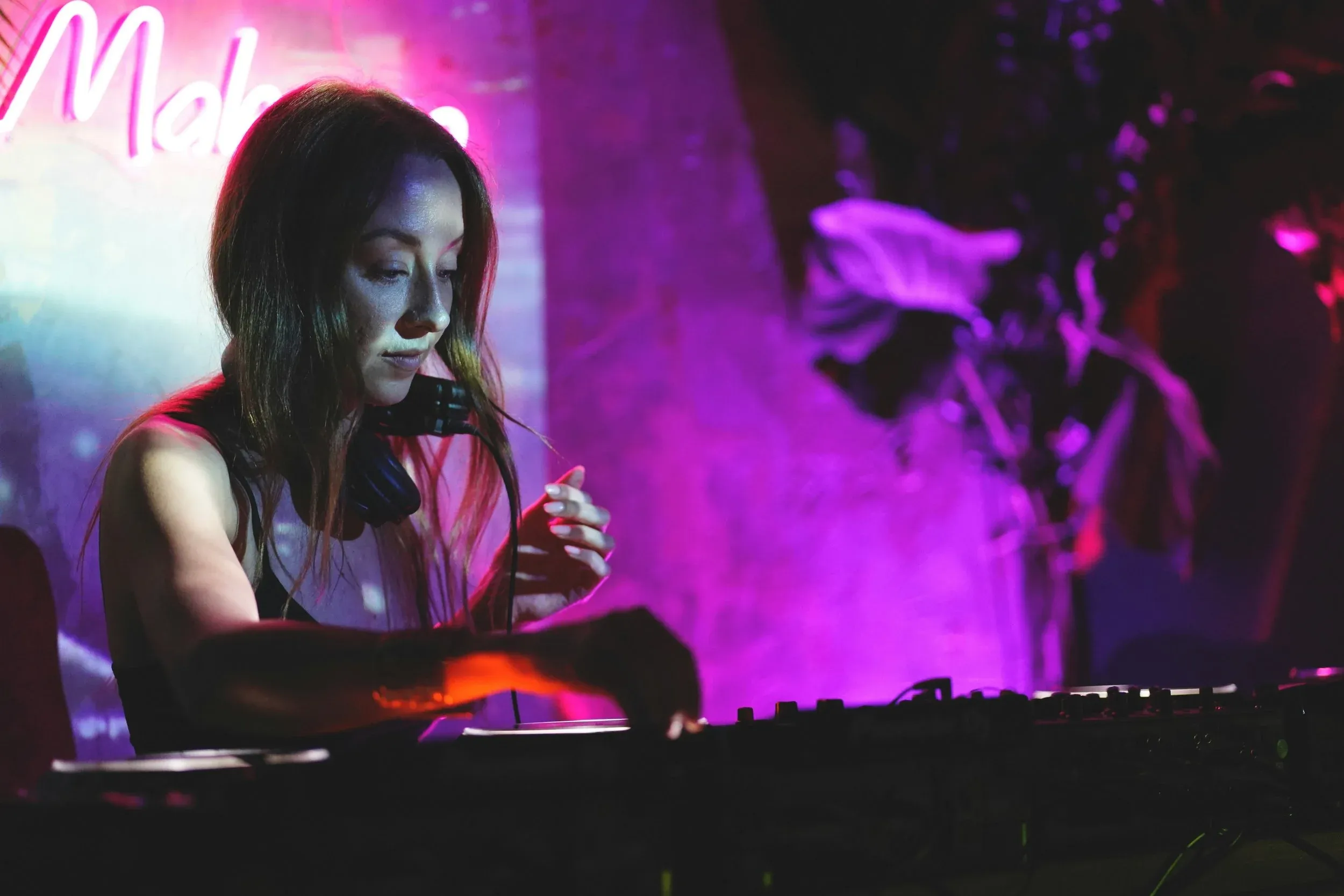 Woman on stage operating electronic audio equipment